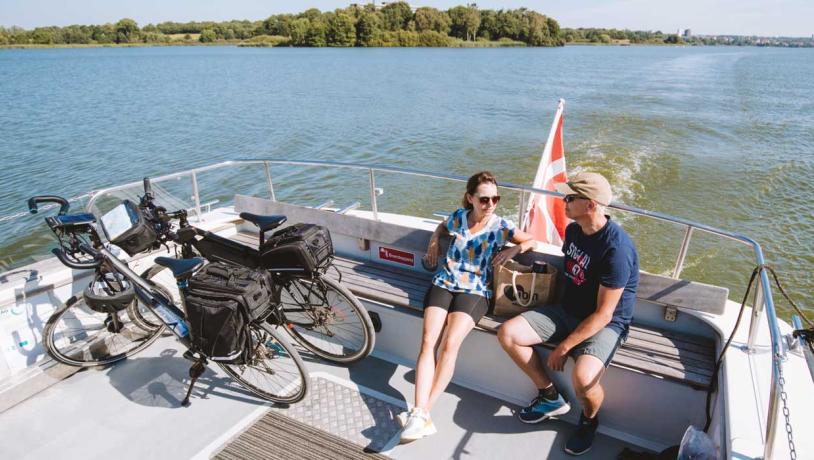 Par med cykler sidder ombord på Haderslev Dambåd