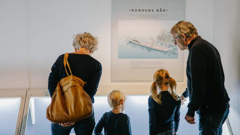 bedsteforældre og børnebørn kigger på en udstilling