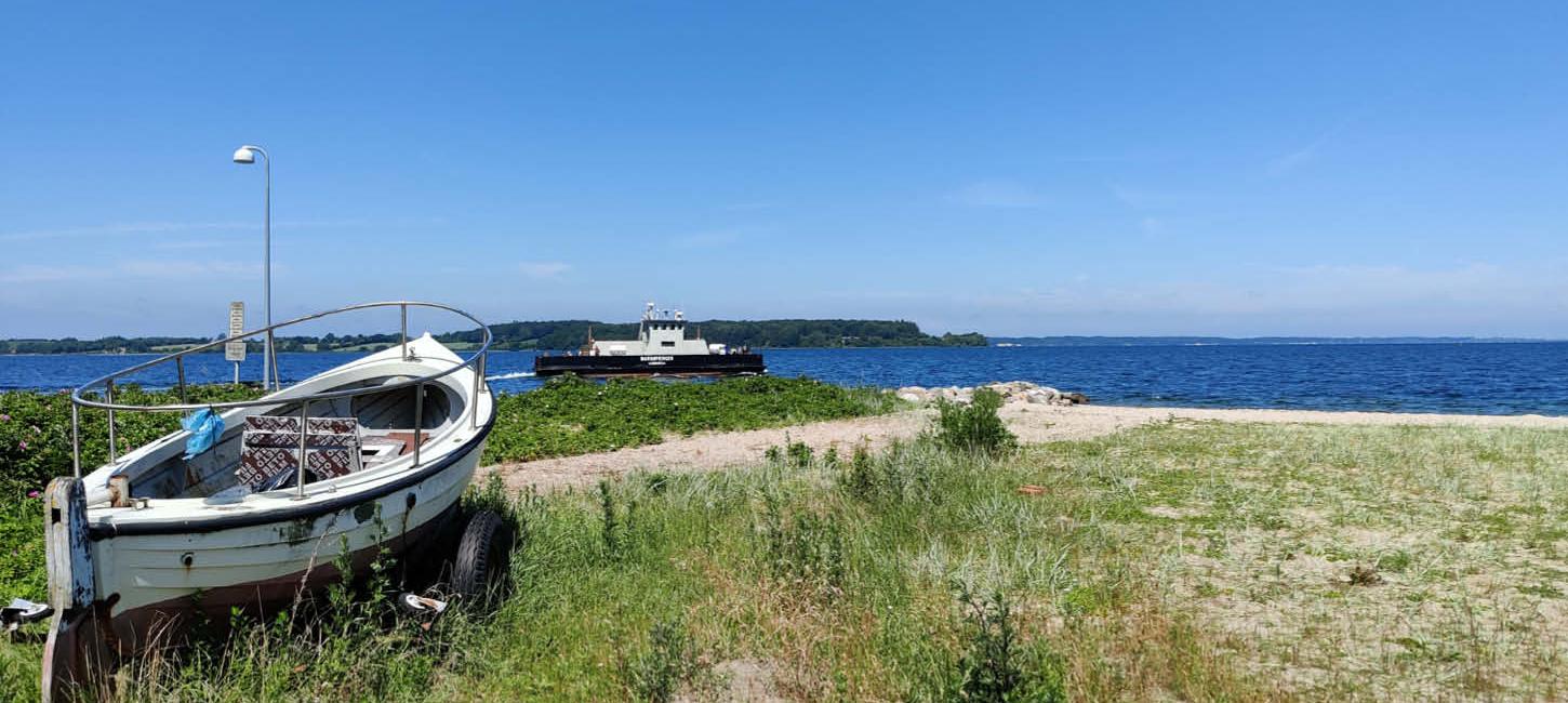 Barsø - boot op het strand, met de veerboot op de achtergrond