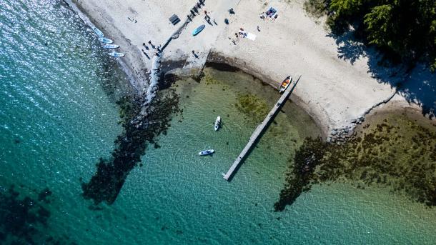Droneskud af strand, med to SUP boards i vandet 