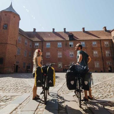 Paar met fietsen op de binnenplaats van het Kasteel van Sønderborg