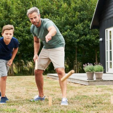 Far og søn spiller Kongespil foran sommerhus