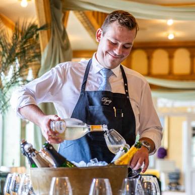 Tjener skænker vin på Dyvig Badehotel