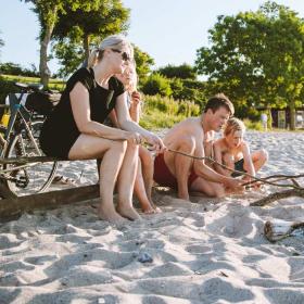 Gezin met fietsen bij een kampvuur op het strand